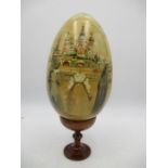 A hand painted Russian Matryoshka egg with 9 sections showing traditional scenes along with a stand