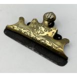 A brass letter clip marked D.G.M.S.A