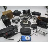 A collection of cameras including an Olympus XA2, a Panasonic Lumix DMC FX-10, a Canon Powershot