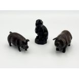 A wooden netsuke in the form of a sow along with two other wooden pigs all signed