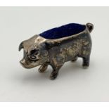 A hallmarked silver pin cushion in the form of a pig