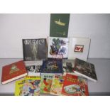 A collection of various books including Marvel Comic book, DC through the years, Art books, Rupert
