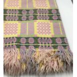 Welsh wool blanket woven in pink, pale yellow and green with geometric patterns. 140cm x 210cm