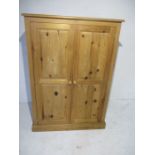 A pine two door cupboard - height 131cm, width 92cm, depth 59cm