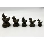 A collection of five Chinese bronze opium weights in the form of cockerels/ducks in graduating