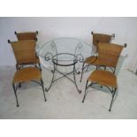 A wrought iron glass topped table with four chairs