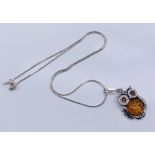 An amber owl pendant mounted in 925 silver with chain