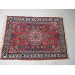 A small red ground Eastern rug, approx. 82cm x 60cm