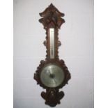 A Victorian Angelinetta & Bregazzi, London heavily carved oak barometer decorated with fruit and the