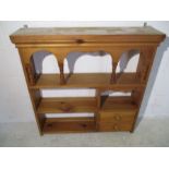 A pine wall shelf with two drawers