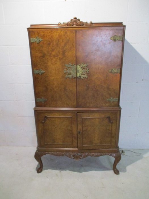 A walnut veneered cocktail cabinet on cabriole legs