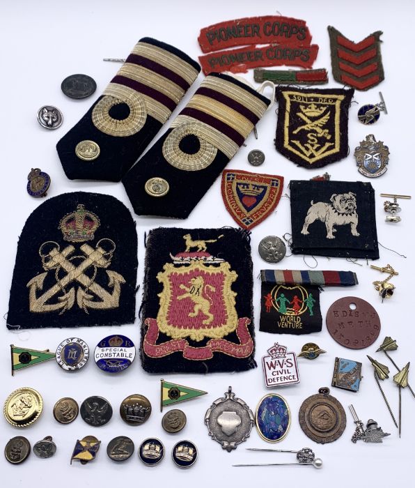 A collection of military badges, epaulettes, buttons etc.