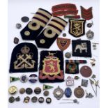 A collection of military badges, epaulettes, buttons etc.