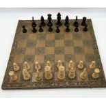 A Tudor Rose carved chess board along with chess pieces (missing one rook)