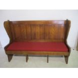 A traditional style settle with upholstered seat