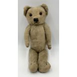 A vintage Merrythought teddy bear with glass eyes, stitched nose and canvas pads. Merrythought
