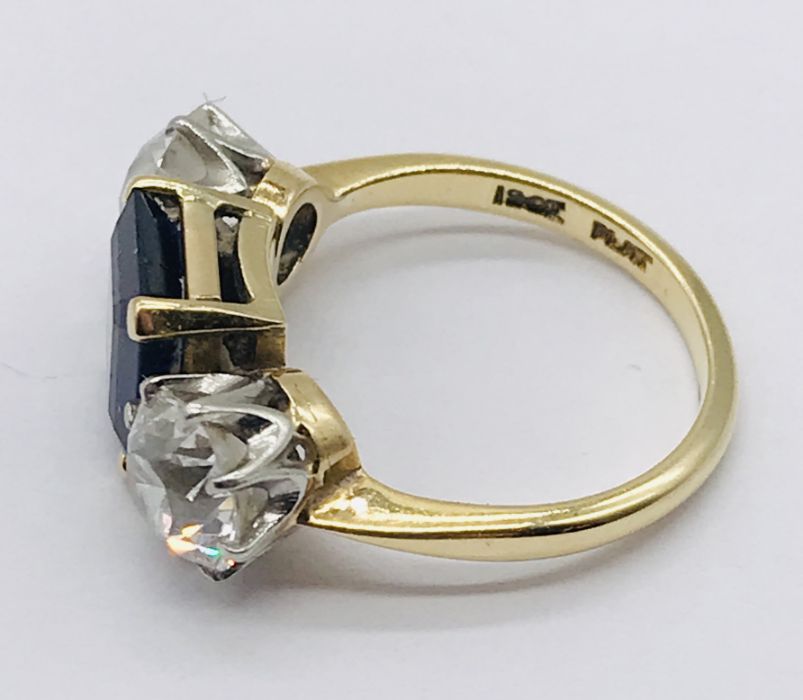 A diamond and sapphire three stone ring. The diamonds measuring 1ct each (6.5mm diameter x 3.75mm - Image 4 of 7