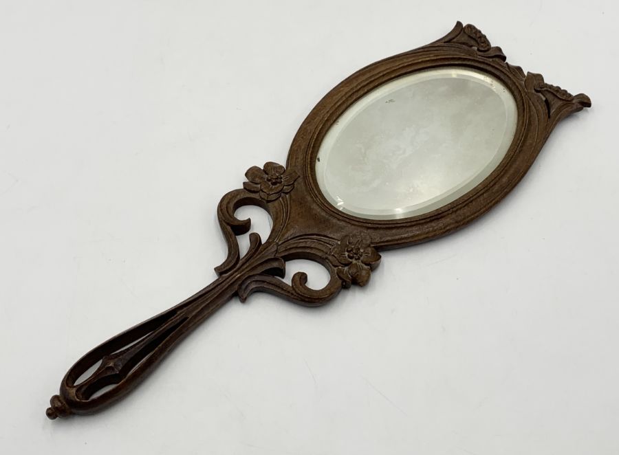 An Art Nouveau carved wooden hand-held dressing mirror