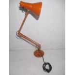 An vintage orange angle poise lamp.