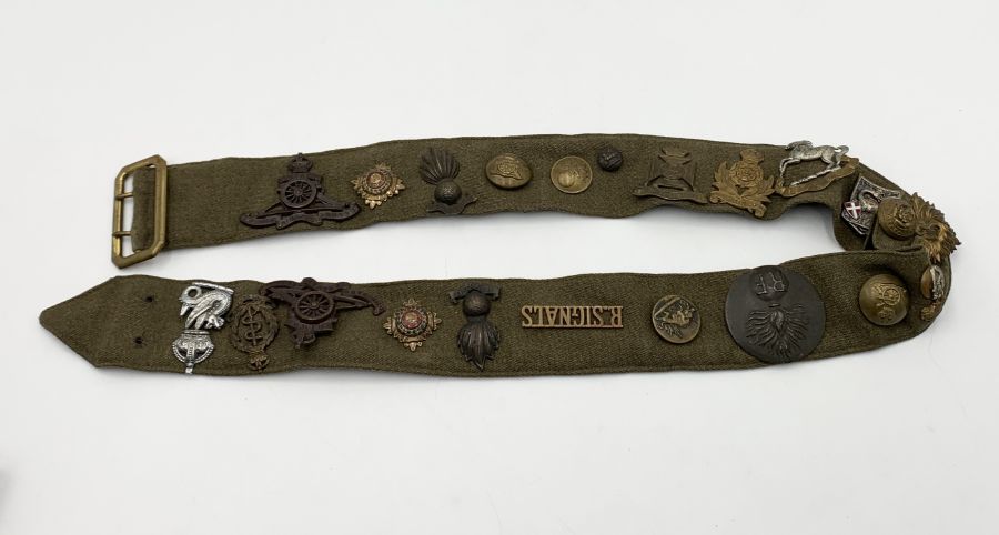 A British Army belt with numerous military cap badges and buttons including Royal Signals, Royal