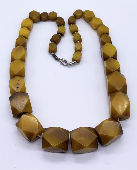 A graduated amber necklace with faceted beads, total weight 169g