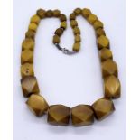 A graduated amber necklace with faceted beads, total weight 169g