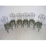 A set of six wrought iron chairs with strap work seats