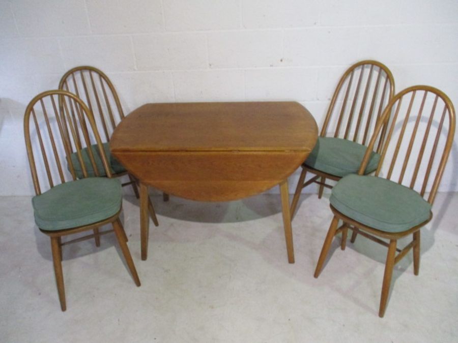 A Priory oak drop leaf table in the style of Ercol with four matching chairs