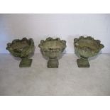 A set of three weathered garden pots