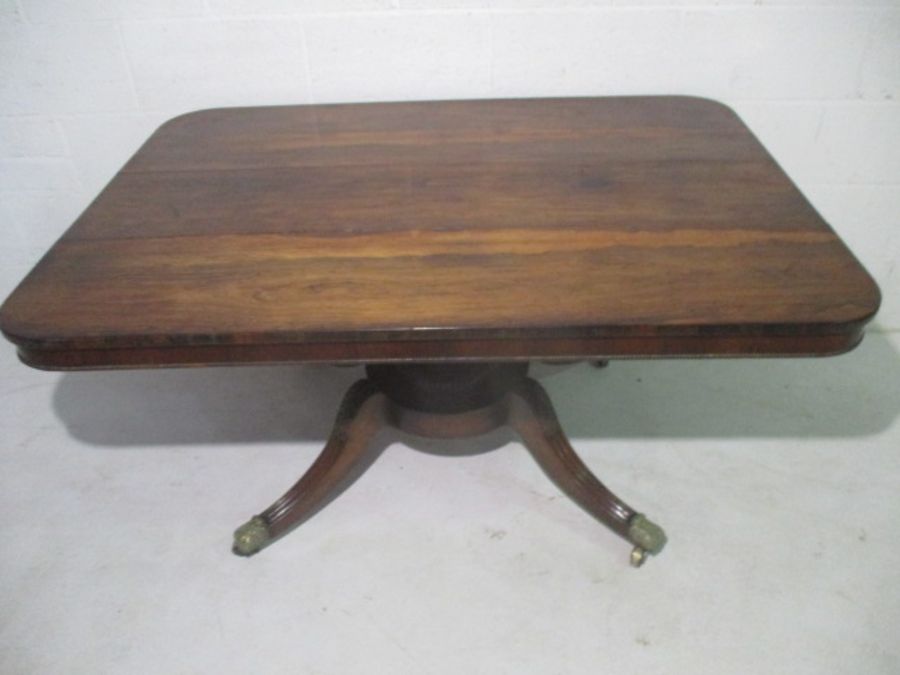 A Victorian rosewood veneered tip up table on quatrefoil legs.