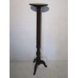 A mahogany torchere on tripod base