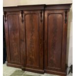A Victorian flame mahogany triple wardrobe with campaign style handles to drawers - one interior