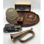 A collection of various items including brass 100 year calendar, bugle, radio in the form of a