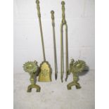 A set of brass fire irons and a pair of fire dogs.