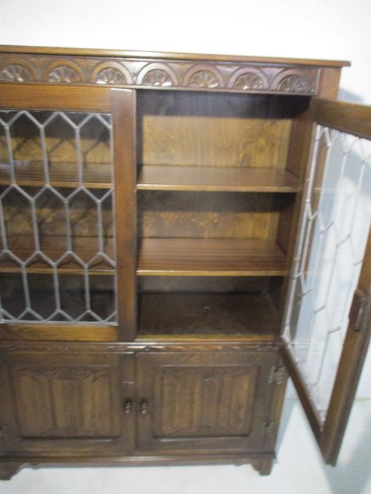An oak display cabinet with linen fold decoration and cupboard under - Image 13 of 13