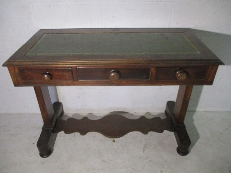 A Victorian centre/writing table with three drawers and leather inset top