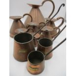 A collection of copper harvest measuring jugs etc