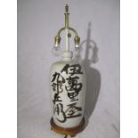 An Oriental pottery lamp decorated with various character marks
