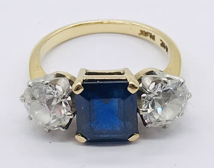 A diamond and sapphire three stone ring. The diamonds measuring 1ct each (6.5mm diameter x 3.75mm - Image 6 of 7