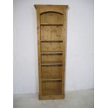 A tall pine narrow bookcase.