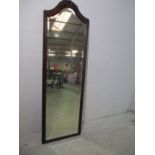 A full length mahogany mirror with carved decoration to top.