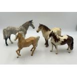 A collection of four Beswick horses including, Highland Pony, Skewbald Pinto Pony, Palomino Prancing