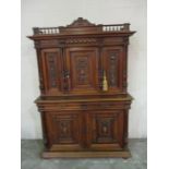 A heavily carved French cupboard with galleried cornice