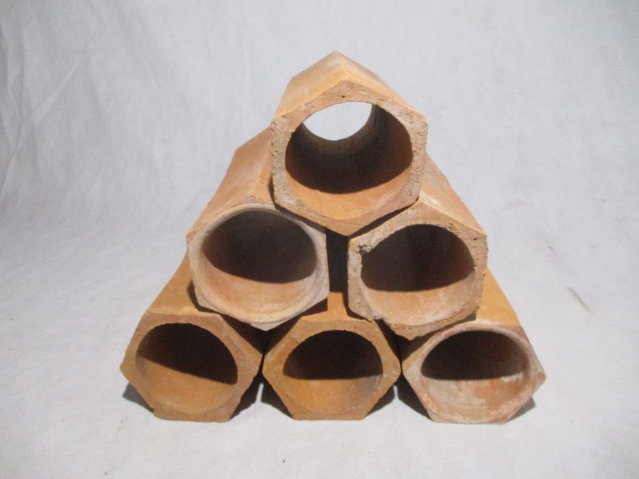 A set of six hexagonal terracotta pipes for wine storage - length 31cm