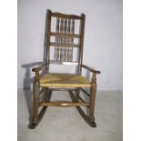 An antique country rocking chair with rush seat.