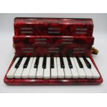 A German "Mini" piano accordion with red marbled finish
