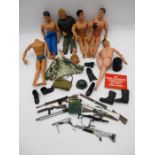 A collection of vintage Action Man figures with various accessories including clothing, weapons,