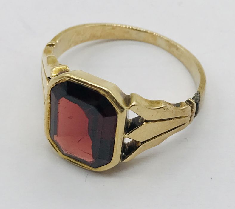 An unmarked gold ring set with a garnet, total weight 4g