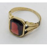 An unmarked gold ring set with a garnet, total weight 4g