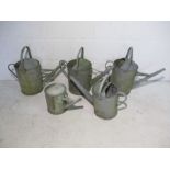 A collection of five vintage galvanised watering cans